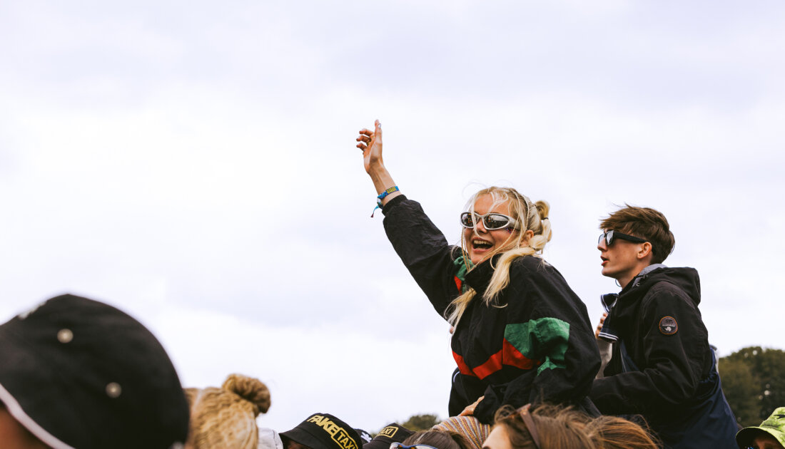 A fan on their friends shoulders at Leeds Festival