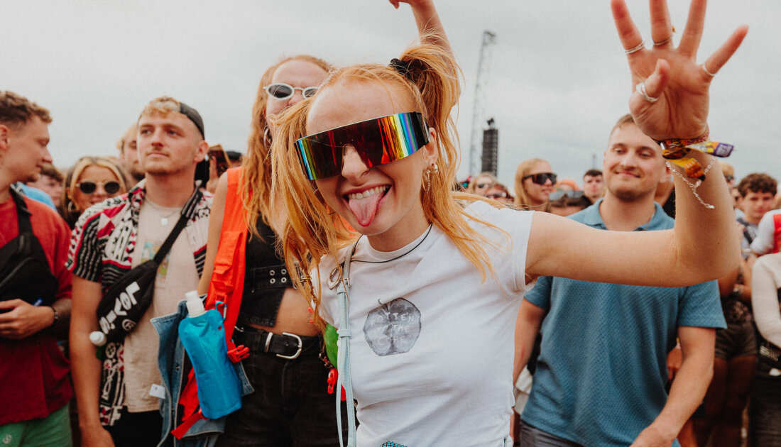 Fan smiling while wearing reflective glasses at Leeds Festival 