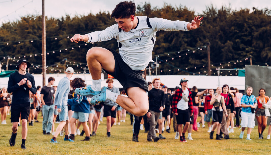 fan doing a high kick in middle of campsite at Leeds festival 