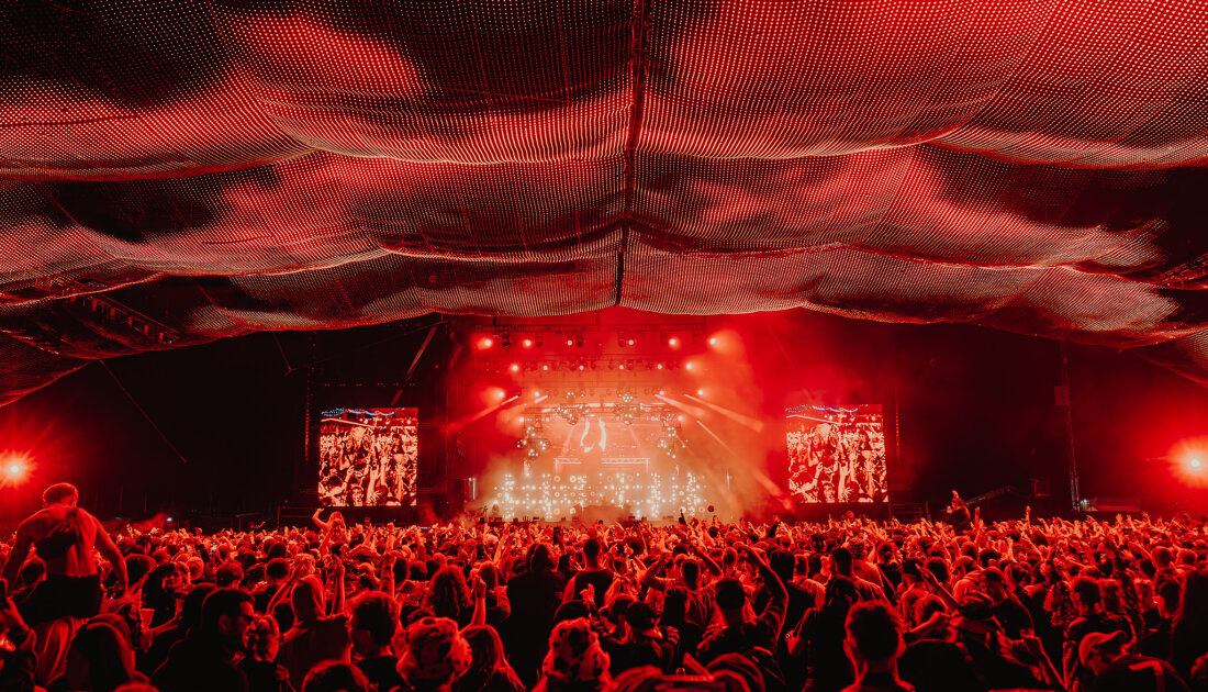 Fans under the orange lights of the Chevron Stage at Leeds Festival