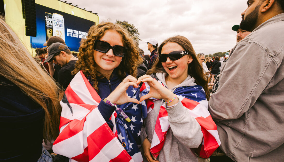 2 fans holding a finger heart with their hands together at Leeds festival