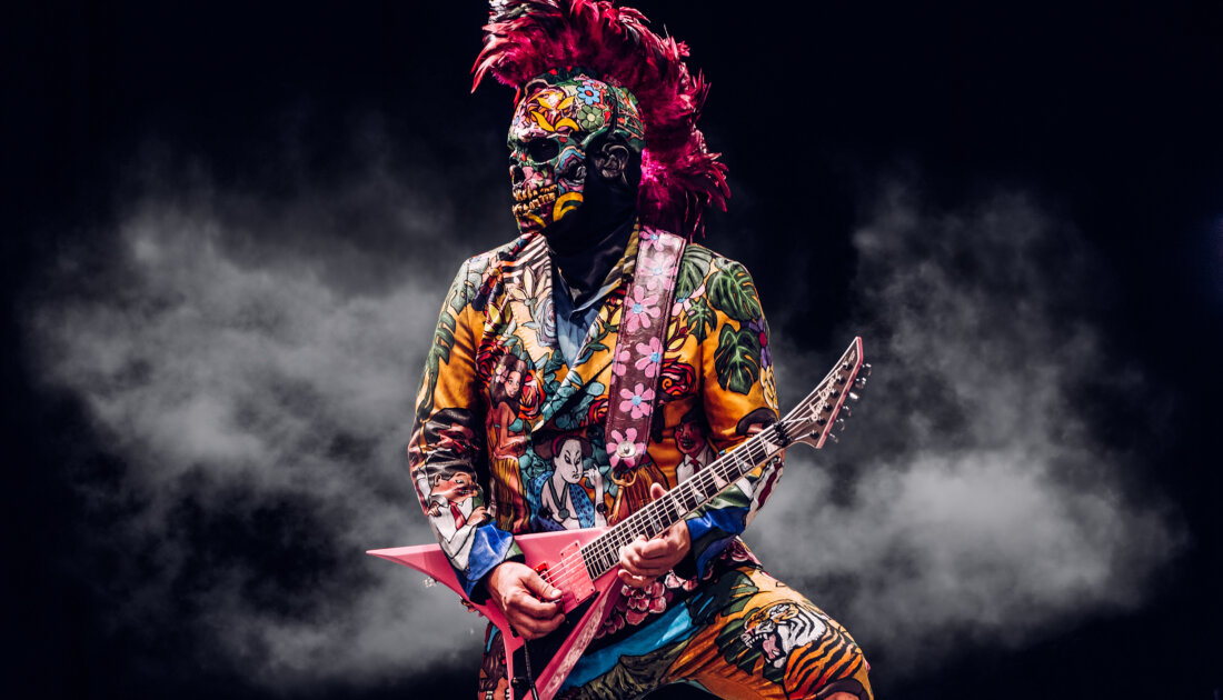 Lead guitarist Wes Borland of Limp Bizkit wearing a flower covered suit and face mask while performing at Leeds Festival 