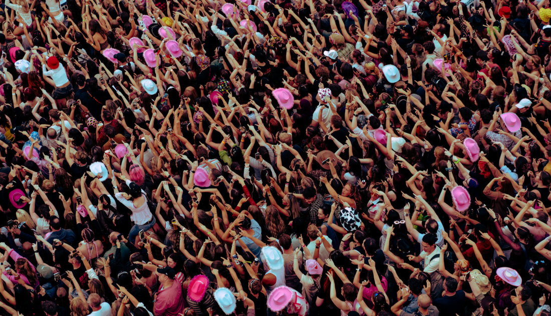Crowd of fans at Leeds Festival wearing pink fluffy cowboy hats 