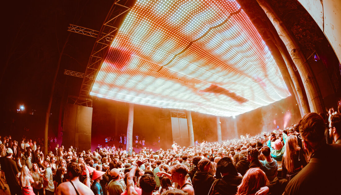 Crowd of fans under the yellow LED lights of the LS23 stage at Leeds Festival 